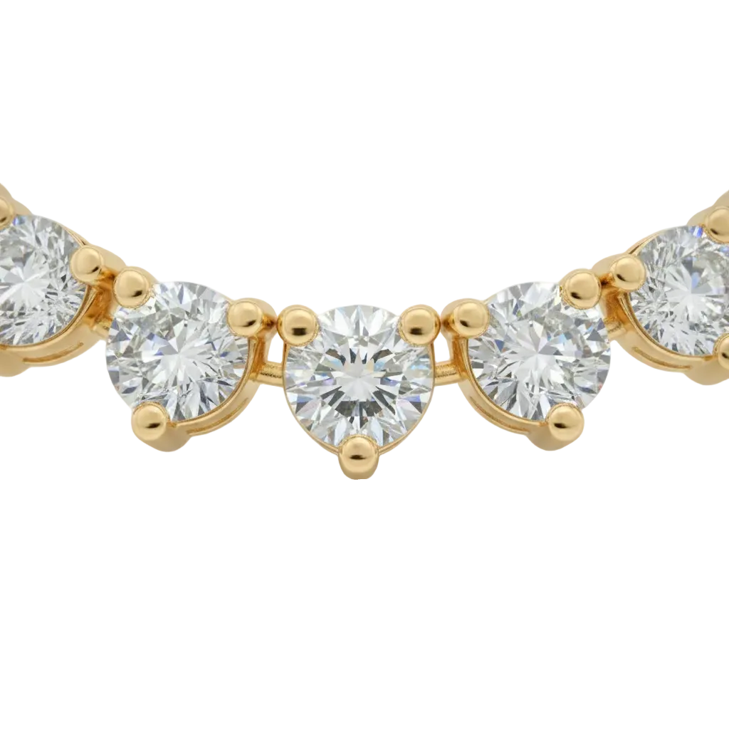 alt="close up of classic three prong round lab grown diamond tennis necklace in 14K yellow gold"
