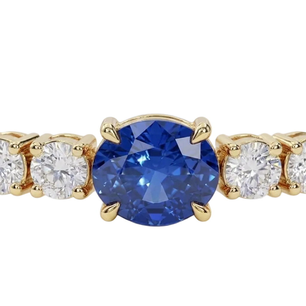 alt="close up view of lab grown oval blue sapphire and round diamond east-west tennis bracelet in 14k yellow gold"