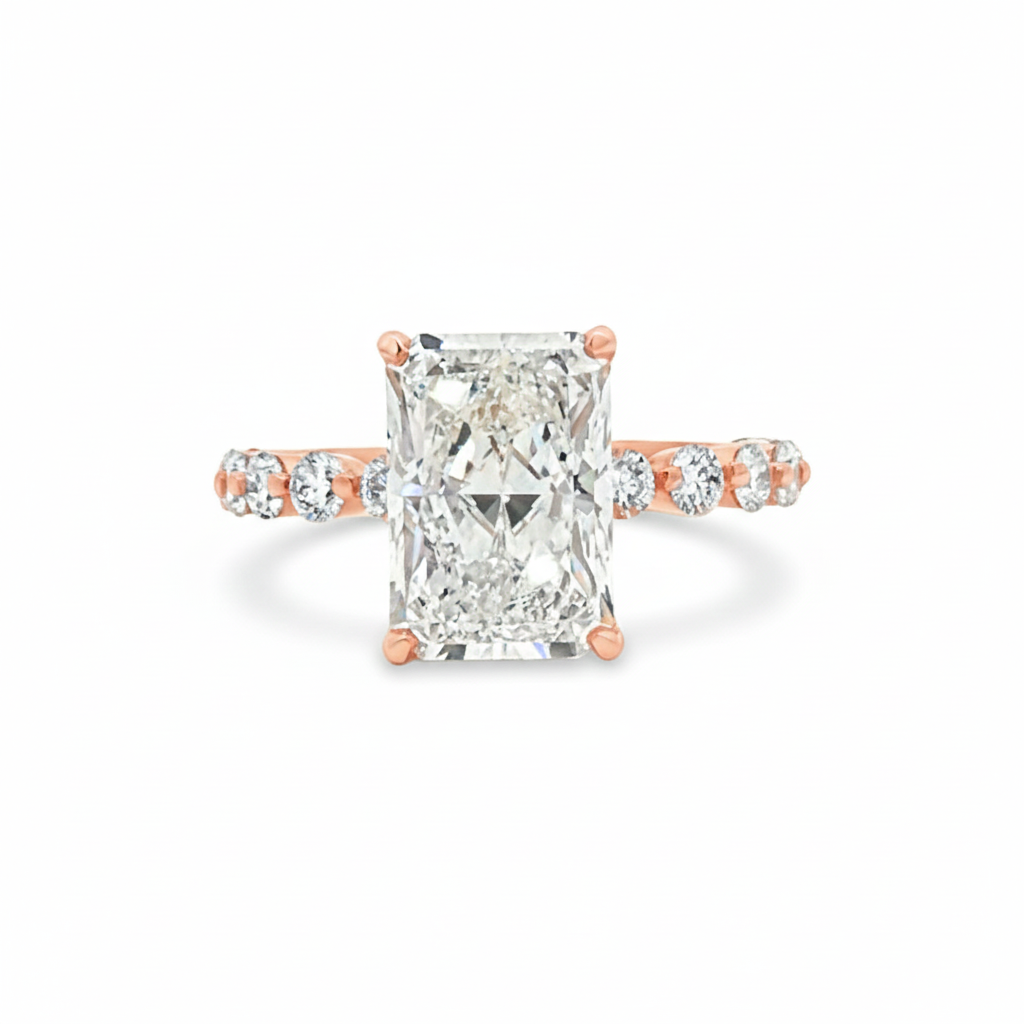 alt="front view of lab grown radiant cut diamond engagement ring with accented band and hidden halo in 14K rose gold"