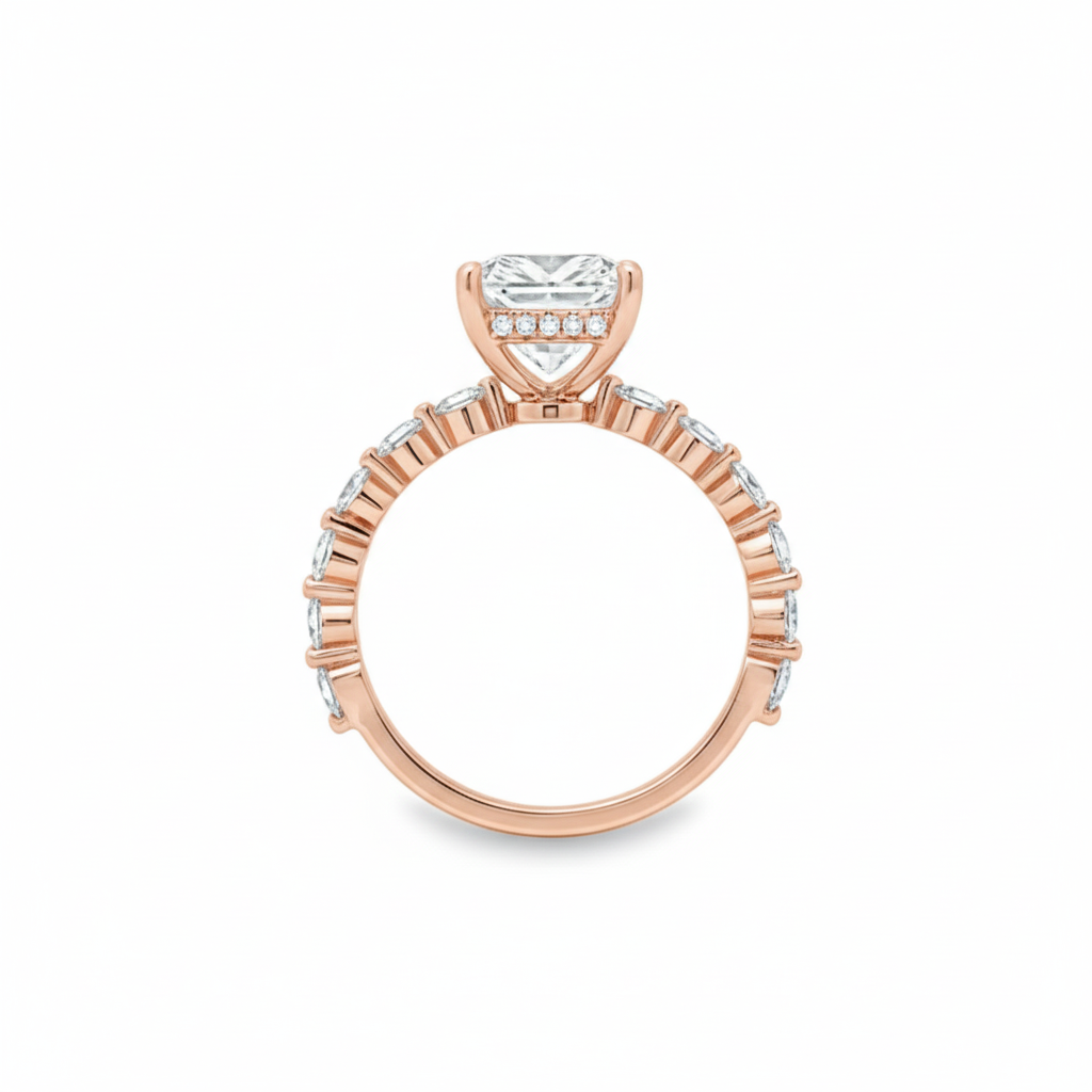 alt="profile view of lab grown radiant cut diamond engagement ring with accented band and hidden halo in 14K rose gold"