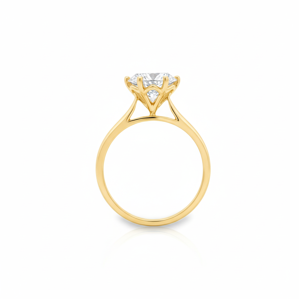 alt="profile view of lab grown round cut diamond four prong setting solitaire engagement ring in 14K yellow gold"