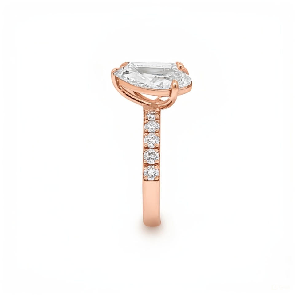 alt="side view of lab grown pear and emerald cut diamond toi et moi ring in 14K rose gold"