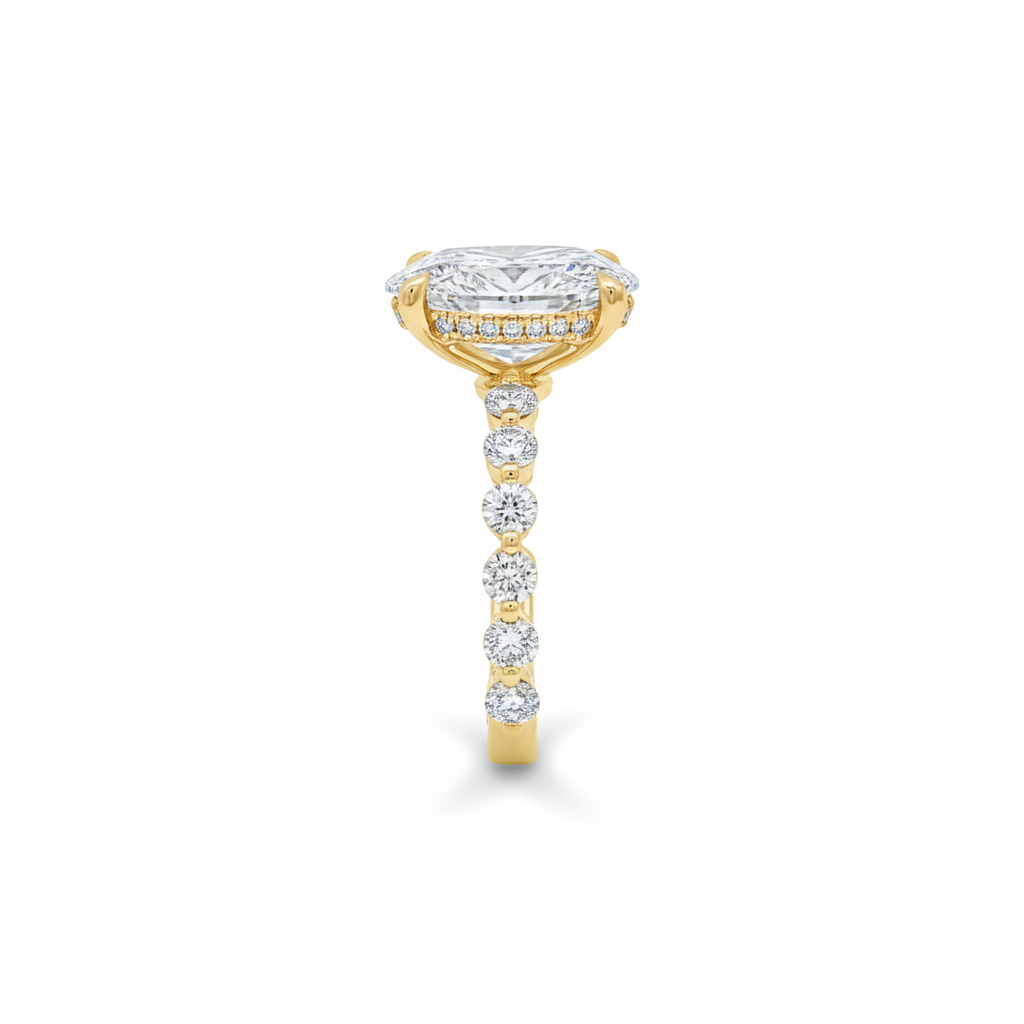 alt="side view of lab grown oval cut diamond engagement ring with accented band in 14K yellow gold"