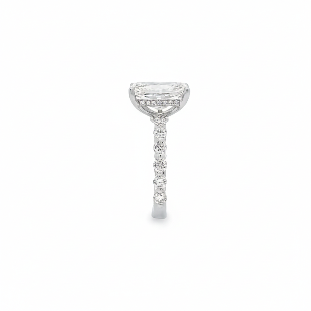 alt="side view of lab grown radiant cut diamond engagement ring with accented band and hidden halo in 14K white gold"