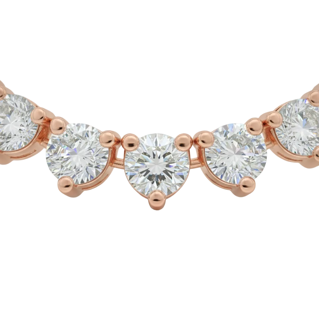 alt="close up of classic three prong round lab grown diamond tennis necklace in 14K rose gold"