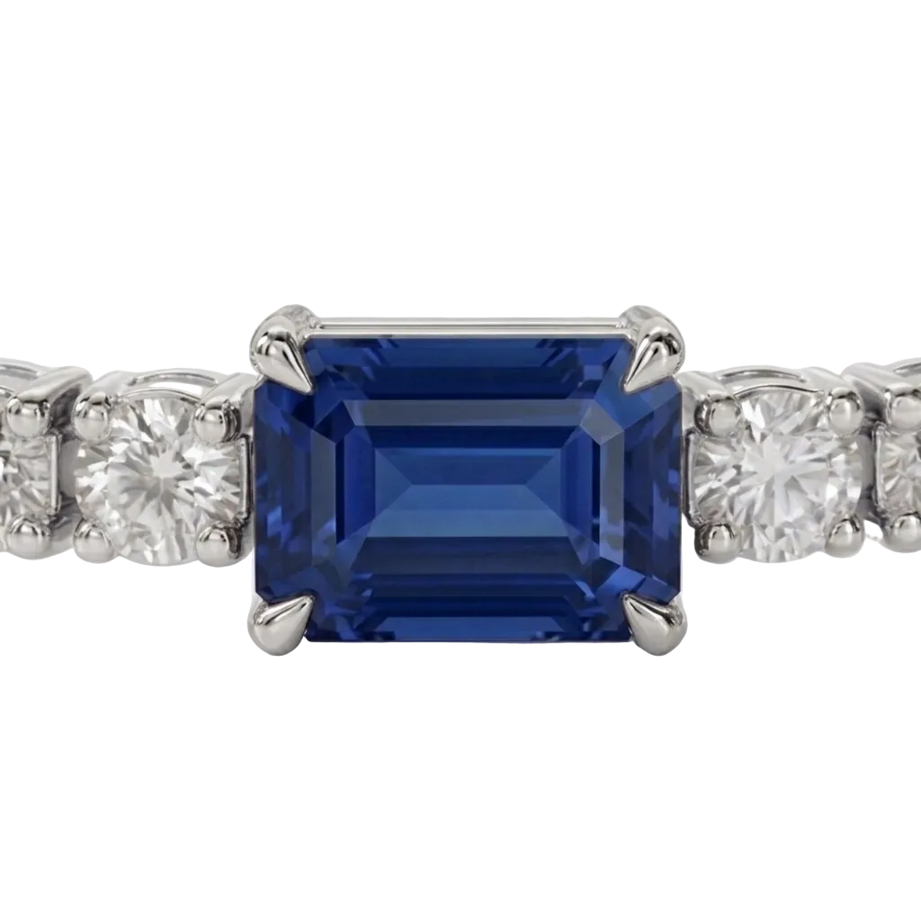 alt="close up view of lab grown emerald cut blue sapphire and round diamond east-west tennis bracelet in 14k white gold"