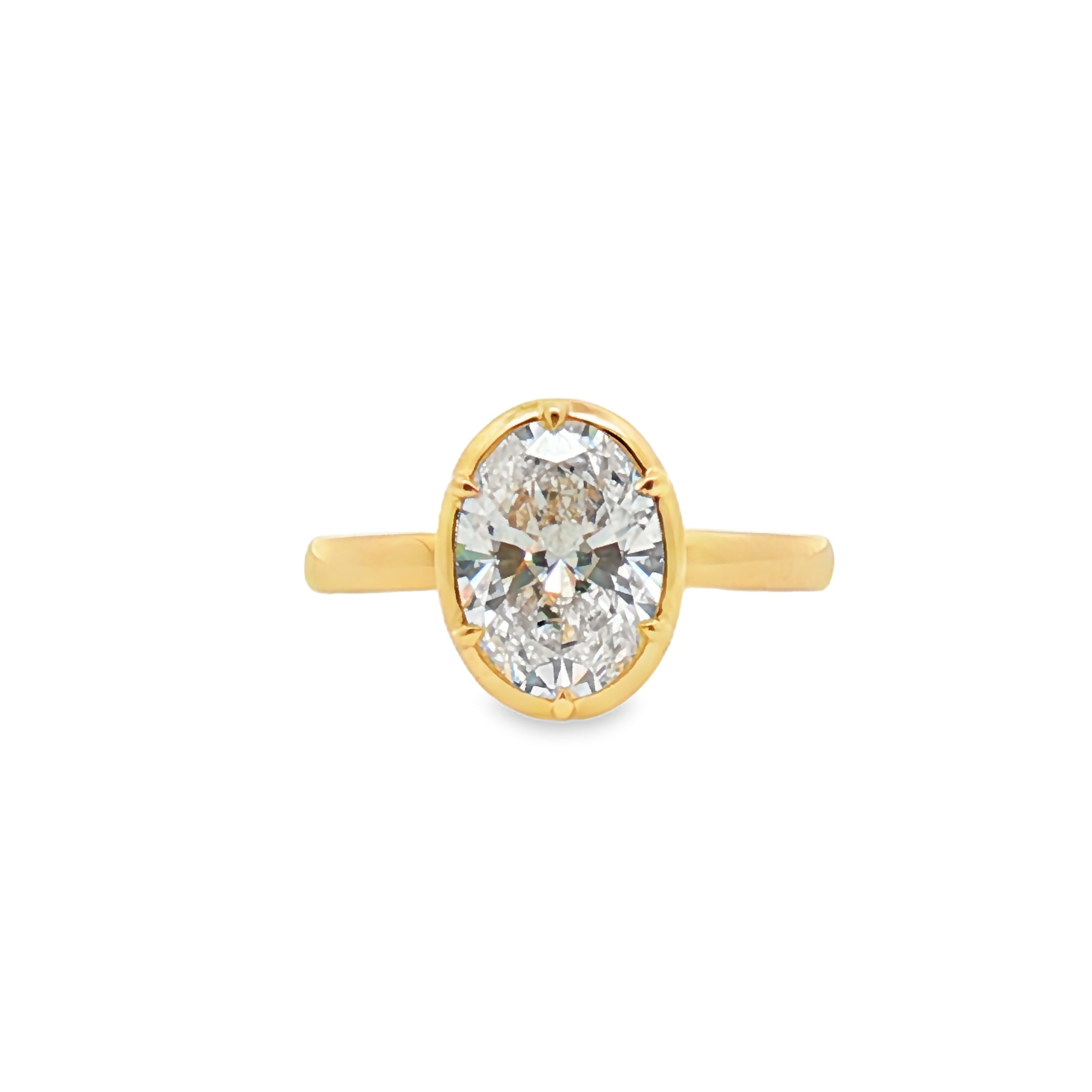 alt="front view of lab grown oval cut diamond bezel set engagement ring in 14K yellow gold"