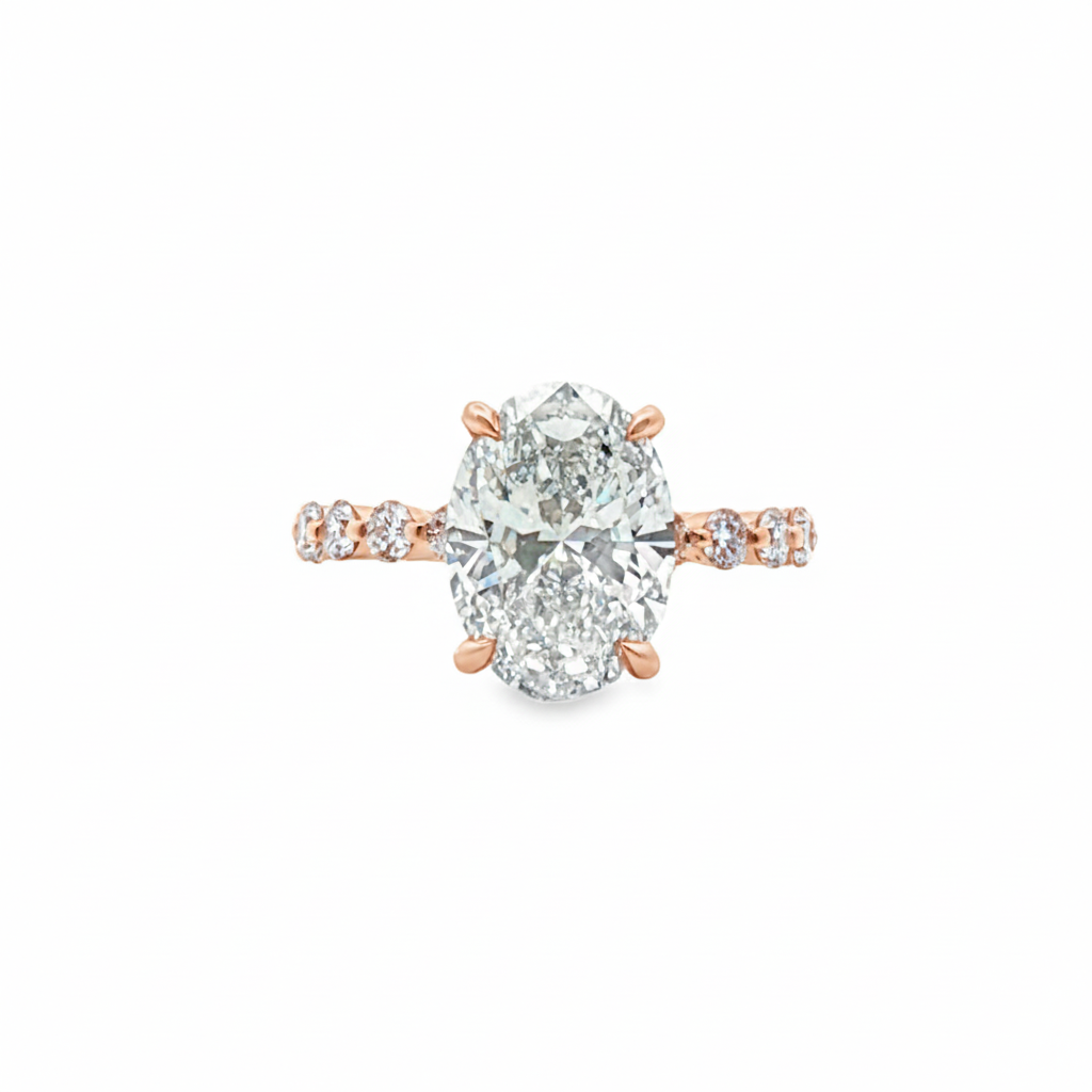 alt="front view of lab grown oval cut diamond engagement ring with accented band in 14K rose gold"