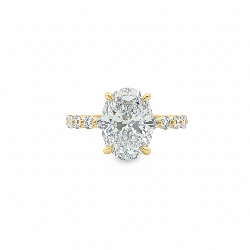 alt="front view of lab grown oval cut diamond engagement ring with accented band in 14K yellow gold"