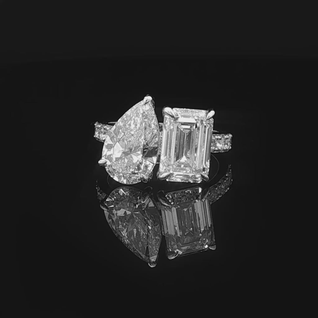alt="360 video of lab grown pear and emerald cut diamond toi et moi ring in 14K white gold"