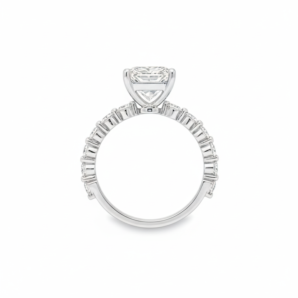 alt="profile view of lab grown radiant cut diamond engagement ring with accented band and hidden halo in 14K white gold"