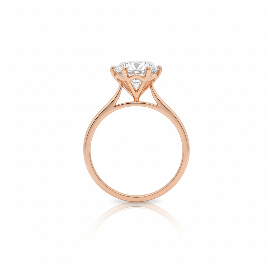 alt="profile view of lab grown round cut diamond four prong setting solitaire engagement ring in 14K rose gold"