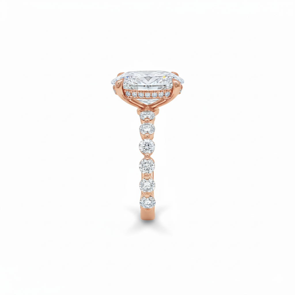 alt="side view of lab grown oval cut diamond engagement ring with accented band in 14K rose gold"